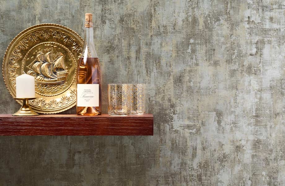Étagère flottante en bois, grande assiette dorée, bouteille de vin et verres près d’un mur-décor en stratifié métallique Homapal Dorure Métallique